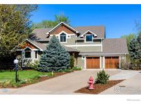 Charming two-story home featuring a well-manicured lawn, mature trees, and a welcoming two-car garage at 7905 Wellshire Ct, Niwot, CO 80503