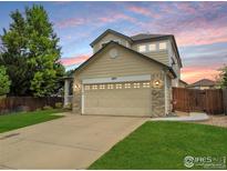 Charming two-story home with a two-car garage and well-maintained lawn at 1204 Ptarmigan Dr, Longmont, CO 80504