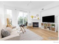 Bright living room boasts large windows, a fireplace, and stylish decor, creating a cozy atmosphere at 1866 Mallard Dr, Superior, CO 80027