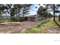 Charming single-story home with a two-car garage, a front porch, and mountain views surrounded by tall trees at 258 Post Boy Rd, Boulder, CO 80302