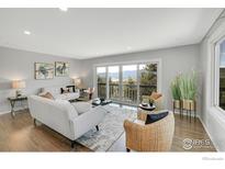 Bright living room featuring hardwood floors, neutral paint, and a sliding door with beautiful mountain views at 258 Post Boy Rd, Boulder, CO 80302
