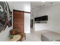 Modern kitchen featuring sleek cabinetry, stainless steel appliances, and a unique sliding barn door at 3090 W 107Th Pl # C, Westminster, CO 80031