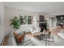 Bright living room with a fireplace, a large window, and modern furniture at 3335 Chisholm Trl # 202, Boulder, CO 80301