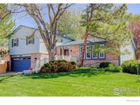 Charming home featuring a brick facade, blue trim, attached garage and a well-maintained lawn at 470 Ash St, Broomfield, CO 80020