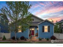 Charming blue home featuring a well-manicured lawn and landscaped garden beds at 569 Jackson St, Lafayette, CO 80026