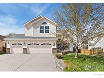 Charming two-story home with a three car garage and well-maintained lawn in a desirable neighborhood at 5910 Blue Mountain Cir, Longmont, CO 80503