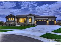 Charming home featuring a stone facade, three-car garage and manicured lawn at 685 Quarry Ct, Erie, CO 80516