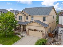 Charming two-story home features a two-car garage, manicured lawn, and inviting front porch at 687 Jarvis Dr, Erie, CO 80516