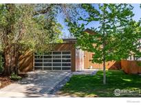 Modern home featuring a glass garage door and a beautifully landscaped front yard at 711 Hawthorn Ave, Boulder, CO 80304
