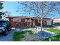 Charming brick home with manicured front yard and lush landscaping at 8089 Greenwood Blvd, Denver, CO 80221