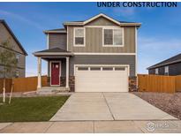 Charming two-story home features a red door, a two-car garage, and a well-maintained lawn at 816 Leeward St, Lochbuie, CO 80603