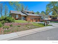 Charming brick home featuring a well-kept yard and three-car garage at 128 Baylor Dr, Longmont, CO 80503