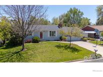 Charming single-story home featuring a well-manicured lawn, mature trees, and an attached two-car garage at 1322 Wicklow St, Boulder, CO 80303