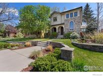 Stunning two-story home with landscaped yard, stone accents and walkway leading to front entrance and covered porch at 1376 S Clayton St, Denver, CO 80210