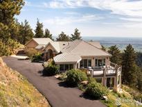 Stunning exterior view of the home with a driveway and an expansive deck overlooking the landscape at 1426 Rembrandt Rd, Boulder, CO 80302
