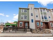 Modern townhouse with a brick facade, green and gray siding, and a ramp to the front door at 14283 Currant St, Broomfield, CO 80020