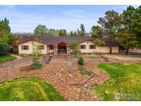 Ranch style house featuring unique rock landscaping, brick accents, and a circular driveway at 14531 Country Hills Dr, Brighton, CO 80601