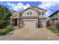 Charming two-story home showcasing a three car garage and craftsman style design at 15453 E 109Th Ave, Commerce City, CO 80022