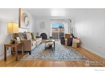 Cozy living room featuring a decorative fireplace, sleek coffee table, and large patterned rug over hardwood floors at 252 N Pennsylvania St # 305, Denver, CO 80203