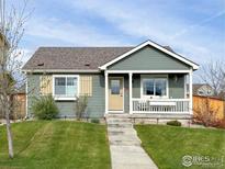 Charming single-story home featuring a well-maintained lawn, inviting porch and walkway at 2793 Red Wheat Trl, Berthoud, CO 80513