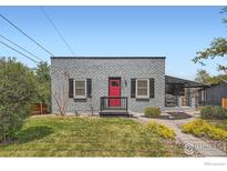 Charming single-story home with gray brick and a bright red front door and landscaped front yard at 4009 W 52Nd Ave, Denver, CO 80212