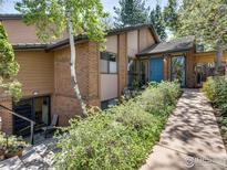 Charming home with brick and wood siding, lush landscaping, and a welcoming blue front door at 700 Poplar Ave, Boulder, CO 80304