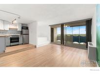 Bright living room featuring hardwood floors and balcony access with scenic views at 1155 N Ash St # 1206, Denver, CO 80220