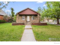Charming brick home featuring a welcoming front yard with a well-maintained lawn and garden at 120 E Nebraska Ave, Berthoud, CO 80513