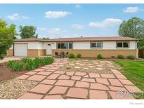 Charming single-story home with stone walkway, brick accents, and lush front yard landscaping at 12734 Anhawa Ave, Longmont, CO 80503