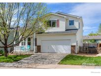 Charming two-story home features a well-manicured front yard and a two-car garage at 1295 Cumberland Dr, Longmont, CO 80504