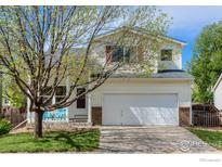 Charming two-story home features a well-manicured front yard and a two-car garage at 1295 Cumberland Dr, Longmont, CO 80504