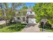 Charming two-story home with a covered front porch, stone accents, and a basketball hoop at 1304 Monarch Ct, Longmont, CO 80504