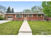 Charming red brick ranch home with a well-manicured lawn and welcoming walkway at 13455 W 21St Pl, Golden, CO 80401