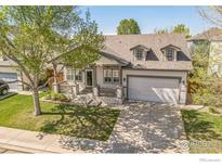 Charming home with a well-manicured front lawn, porch, and an attached two-car garage at 1404 Tonkin Pl, Longmont, CO 80504