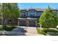 Charming townhome with stone accents, attached garages, and a well-maintained front yard at 2002 E 102Nd Cir, Thornton, CO 80229