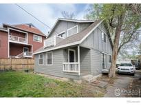 Charming gray two-story home with a small porch and balcony, complemented by a well-maintained lawn and a tree-lined street at 2317 Walnut St, Boulder, CO 80302