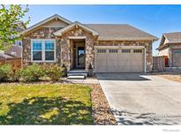 Charming stone-clad home with a well-manicured lawn and a two-car garage, perfect for curb appeal at 2422 E 156Th Pl, Thornton, CO 80602