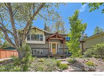 Charming home with a landscaped front yard, inviting entrance, and mature trees at 2550 Woodstock Pl, Boulder, CO 80305