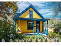 Charming yellow two-story home with blue trim, a welcoming front porch swing, and lovely landscaping at 2645 5Th St, Boulder, CO 80304