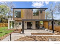 Modern two-story home with wood and stone facade, large windows, and a covered outdoor patio at 2814 3Rd St, Boulder, CO 80304