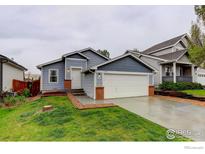 Charming blue home featuring a two-car garage and cozy front yard at 3252 Billington Dr, Erie, CO 80516