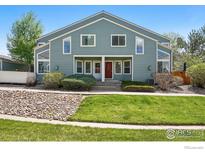 Inviting townhome showcasing a tidy lawn and rock garden, complemented by a charming covered entry at 5180 Buckingham Rd, Boulder, CO 80301