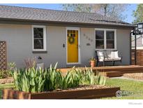 Charming home featuring a cheerful yellow door and a welcoming front porch bench at 6260 W 61St Ave, Arvada, CO 80003