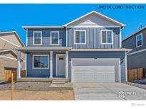 Charming two-story home with a covered porch, large garage and blue siding. Under construction at 6531 14Th St, Frederick, CO 80530