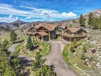 Stunning mountain home with log accents, stone work, circular driveway, and beautiful landscaping at 6553 Sunshine Canyon Dr, Boulder, CO 80302