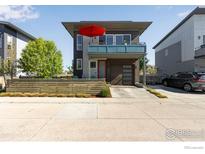 Contemporary two-story home featuring a balcony, vibrant red umbrella, and modern curb appeal at 725 Amelia Ln, Lafayette, CO 80026