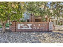 Ashley Court community sign with beautiful brick and stone detail, surrounded by mature trees at 1300 S Monaco Pkwy # 12, Denver, CO 80224