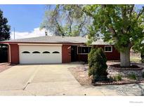 Charming brick home with a well-manicured front yard and a spacious two-car garage at 1701 Jewel Dr, Longmont, CO 80501
