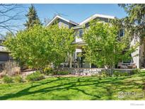 Charming two-story home featuring a welcoming front porch and lush, mature landscaping at 3059 6Th St, Boulder, CO 80304