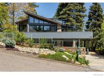 Modern exterior showcases a unique sloped roof, stone accents, and lush landscaping, creating a sophisticated curb appeal at 505 Geneva Ave, Boulder, CO 80302